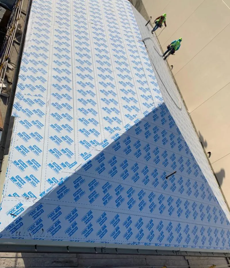 Professional roofers installing underlayment on a metal roof in Fullerton